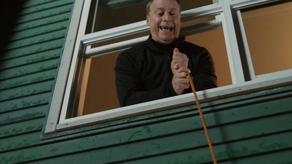 Harry Vanderspeigle pulls on a rope out of a window in Resident Alien Episode 302.