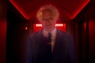 Charles Lee Ray (Brad Dourif) stands in a red-lit hallway in Chucky Episode 306.