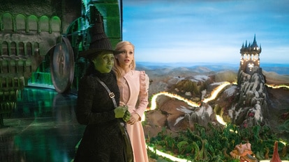 Elphaba and Glinda hold hands and look out to oz in Wicked