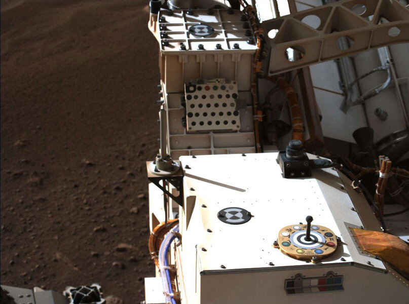 The Perseverance rover’s deck seen from a camera on the mast (the “head”) of the rover showing the severed cables that connected it to the sky crane, as well calibration targets that help engineers adjust the camera settings. The black upward-looking came