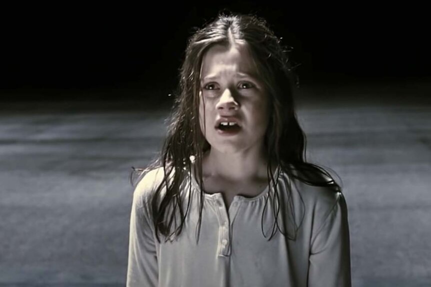 Em (Natasha Calis) is distressed in a white dress in The Possession (2012).
