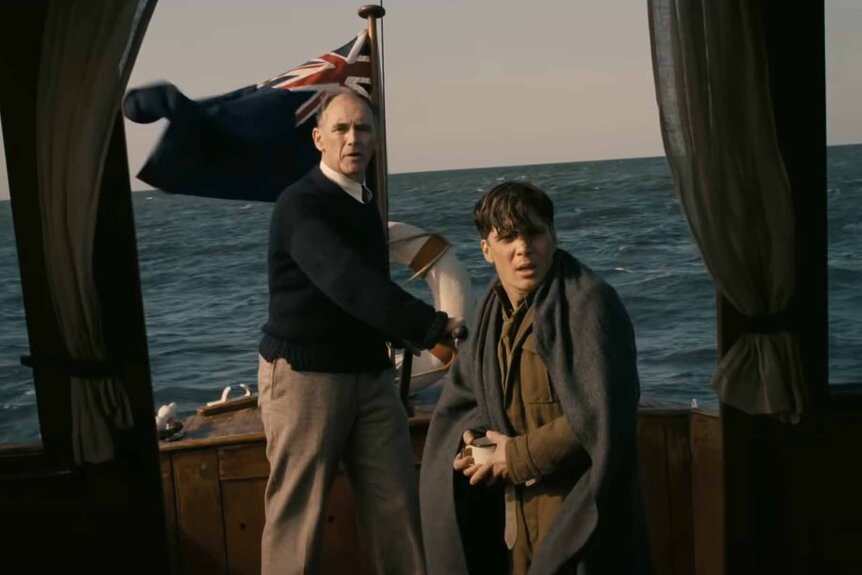 Mr. Dawson (Mark Rylance) and a shivering soldier (Cillian Murphy) stand on a boat in Dunkirk (2017).