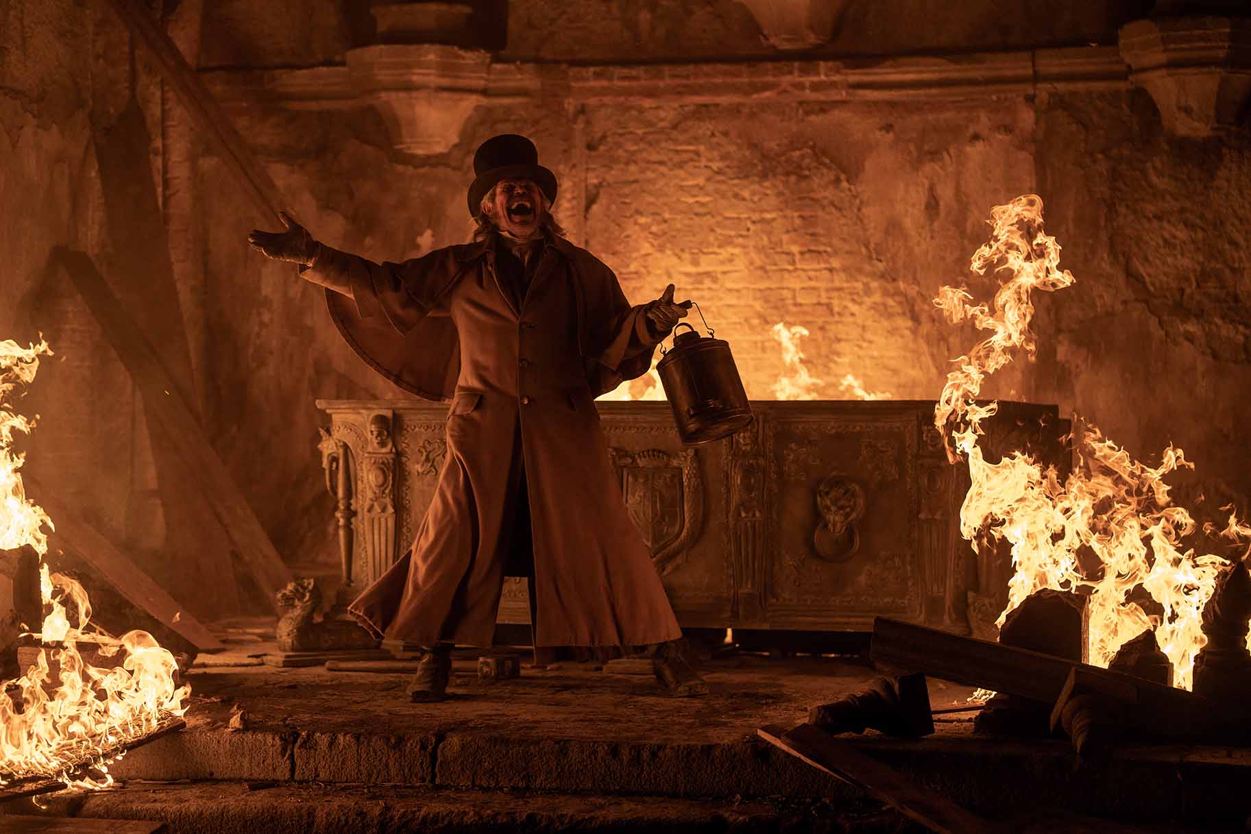 Professor Albin Eberhart von Franz (Willem Dafoe) cackles next to a fiery crypt.