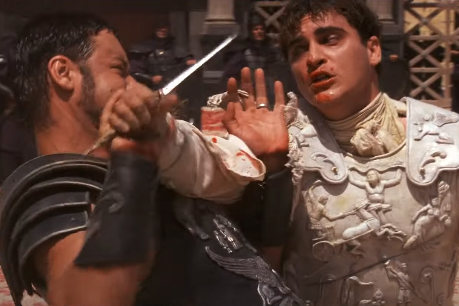 Maximus (Russell Crowe) fight with Commodus (Joaquin Phoenix) who holds a dagger in Gladiator (2000).