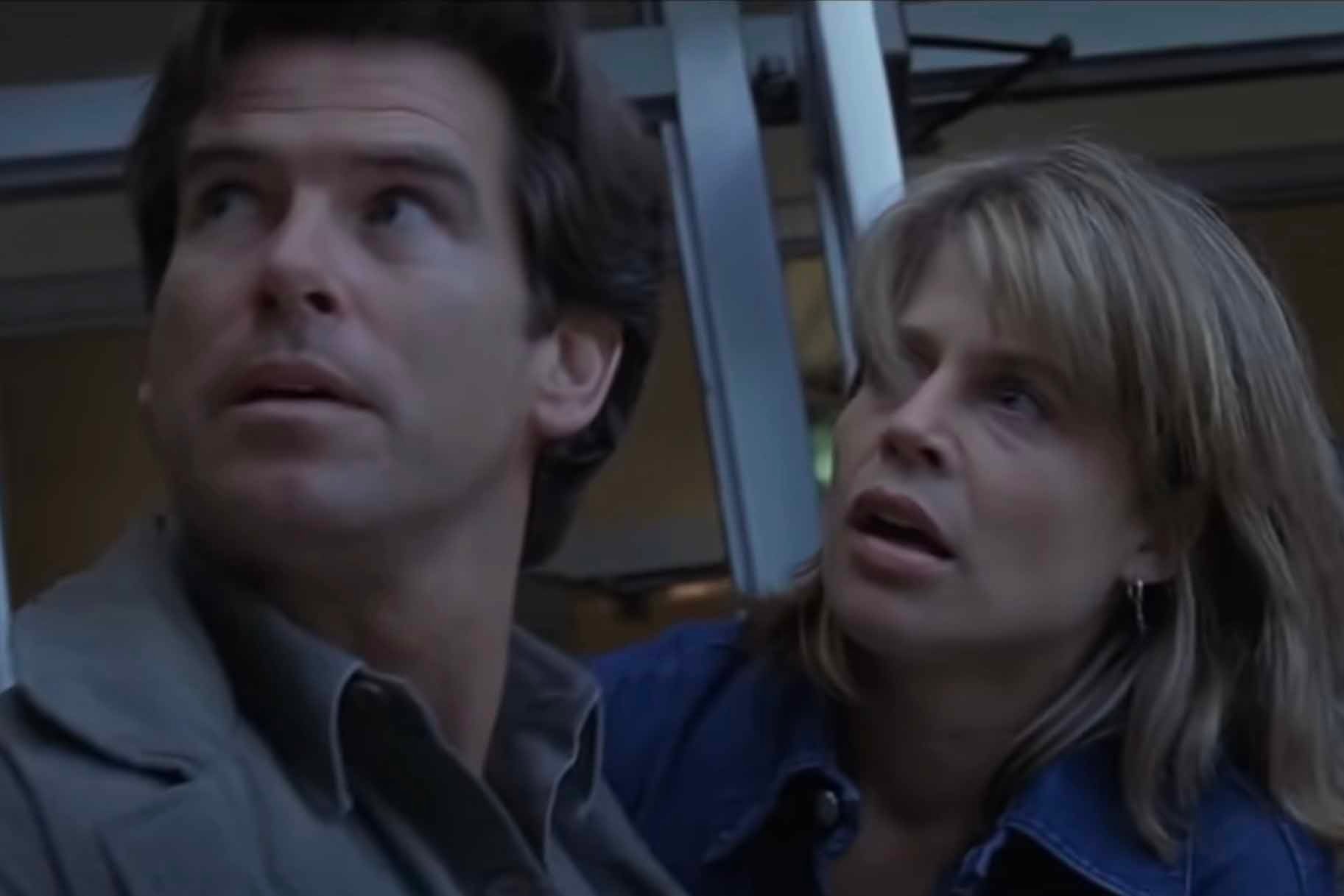 Harry Dalton (Pierce Brosnan) and Rachel Wando (Linda Hamilton) appear frightened in Dante's Peak (1997).