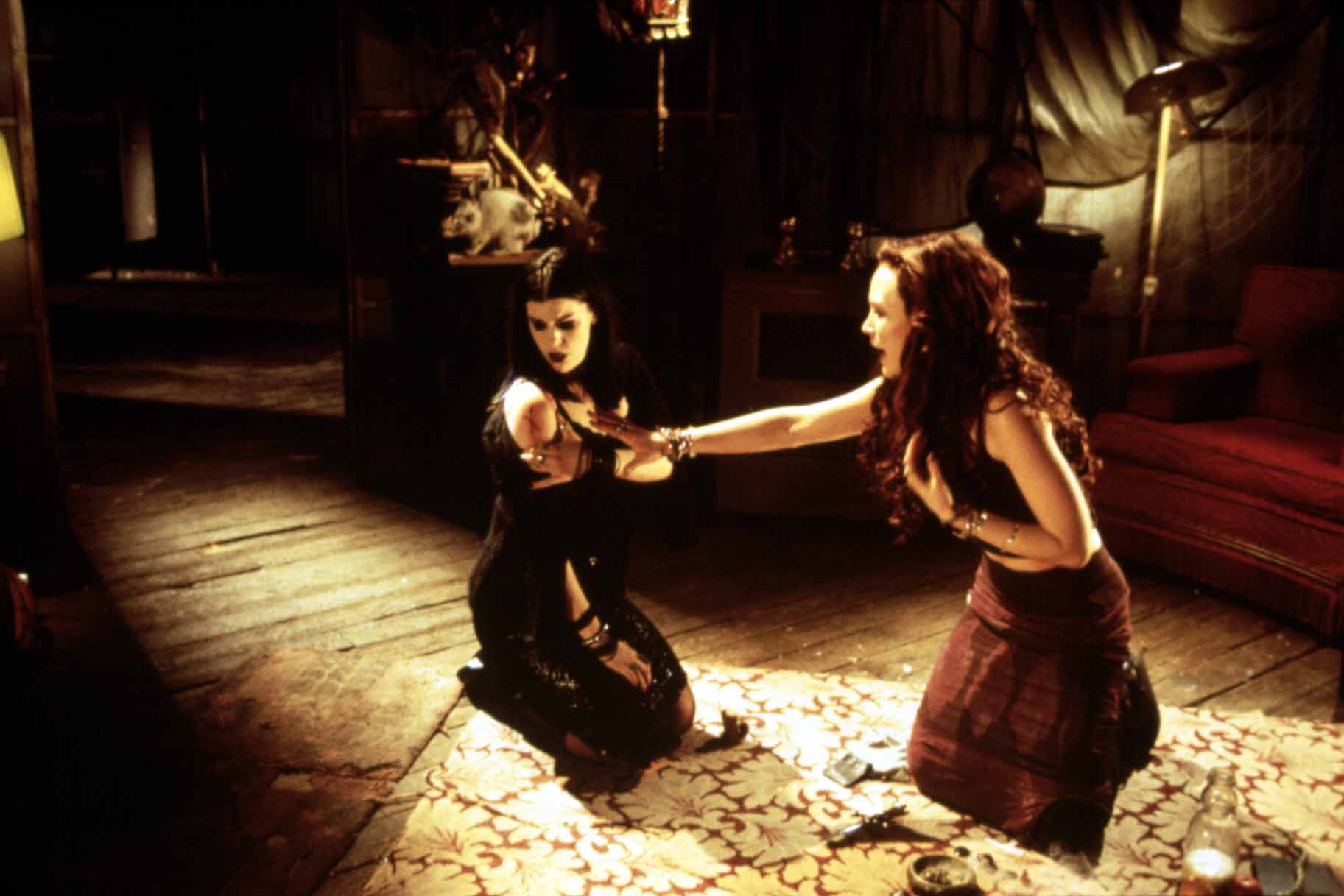 Kim Diamond (Kim Director) looks at a wound on her shoulder as Erica Geerson (Erica Leerhsen) reaches toward it in Book of Shadows: Blair Witch 2 (2000)