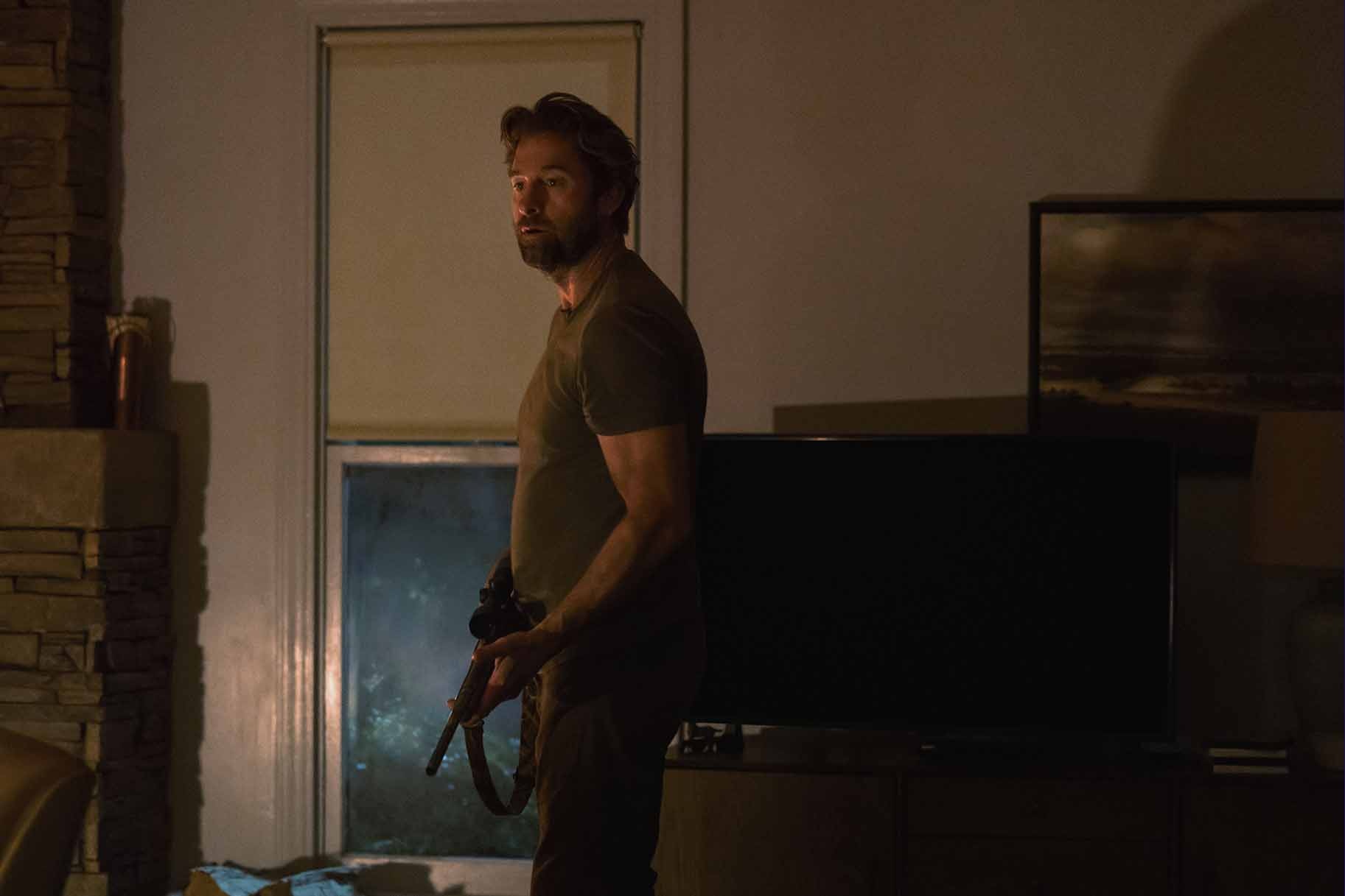 James Chenoweth (Scott Speedman) stands near a window with a gun on Teacup Episode 106.