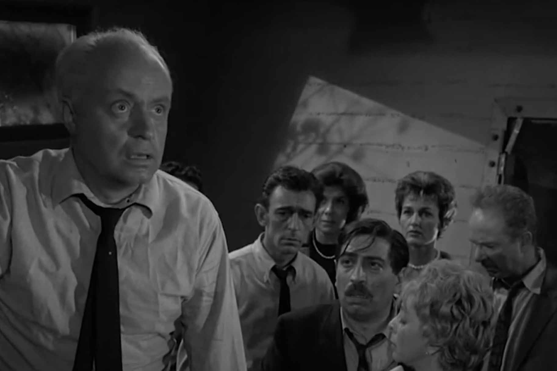 A crowd watches a man in The Twilight Zone Season 3 Episode 3 "The Shelter".