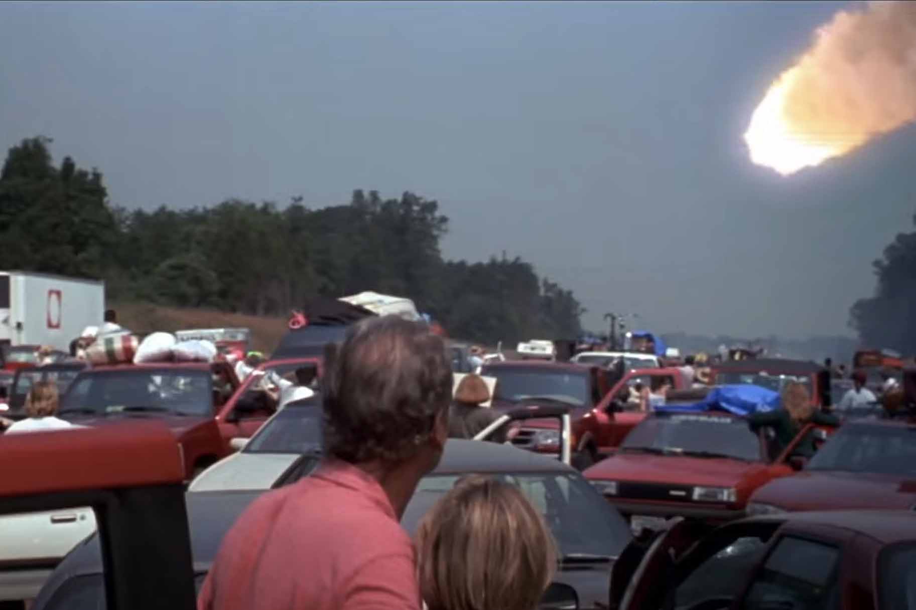 People in bumper to bumper traffic watch an asteroid approach Earth in Deep Impact (1998).