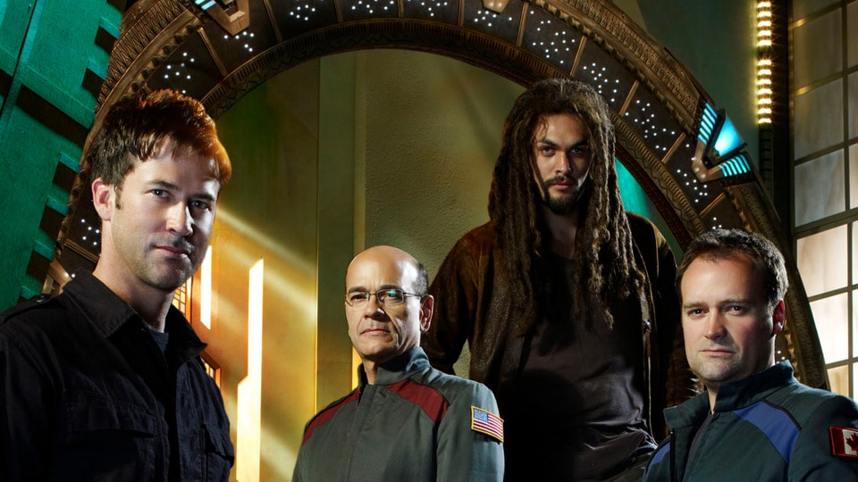 Lt. Col. John Sheppard (Joe Flanigan), Richard Woolsey (Robert Picardo), Ronan Dex (Jason Momoa), and Dr. Rodney McKay (David Hewlett) pose for Stargate Atlantis Season 5.