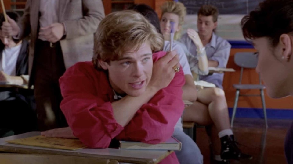 Dwight Ingalls (Brad Pitt) talks to a girl during class on Cutting Class (1989).