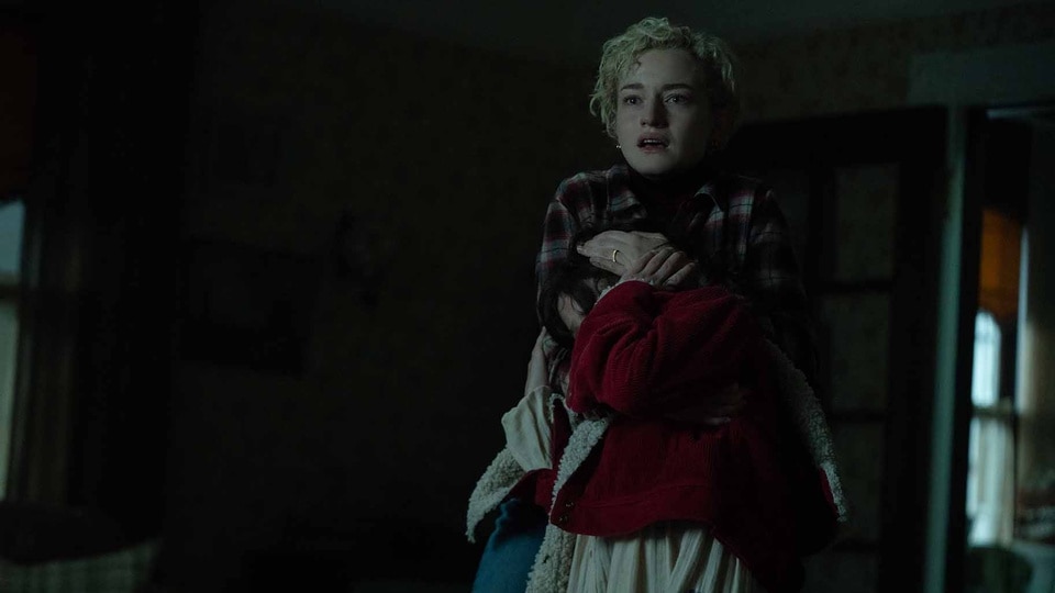 Charlotte (Julia Garner) shields Ginger (Matilda Firth) in Wolf Man (2024).