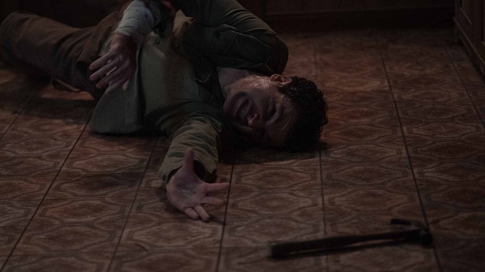 Blake (Christopher Abbott) writhes on the ground and reaches for a hammer in Wolf Man (2024).