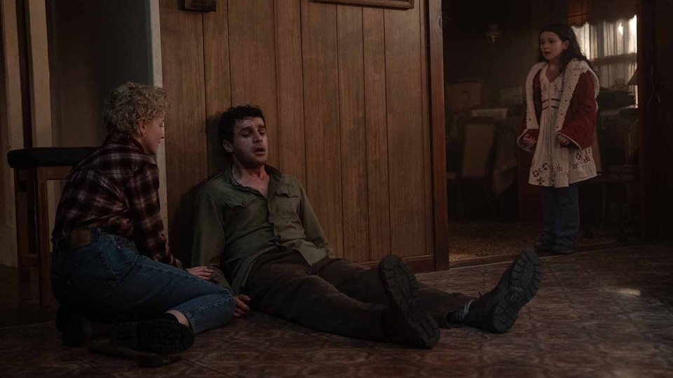 Charlotte (Julia Garner) and Ginger (Matilda Firth) look at an injured Blake (Christopher Abbott) appears in Wolf Man (2024).