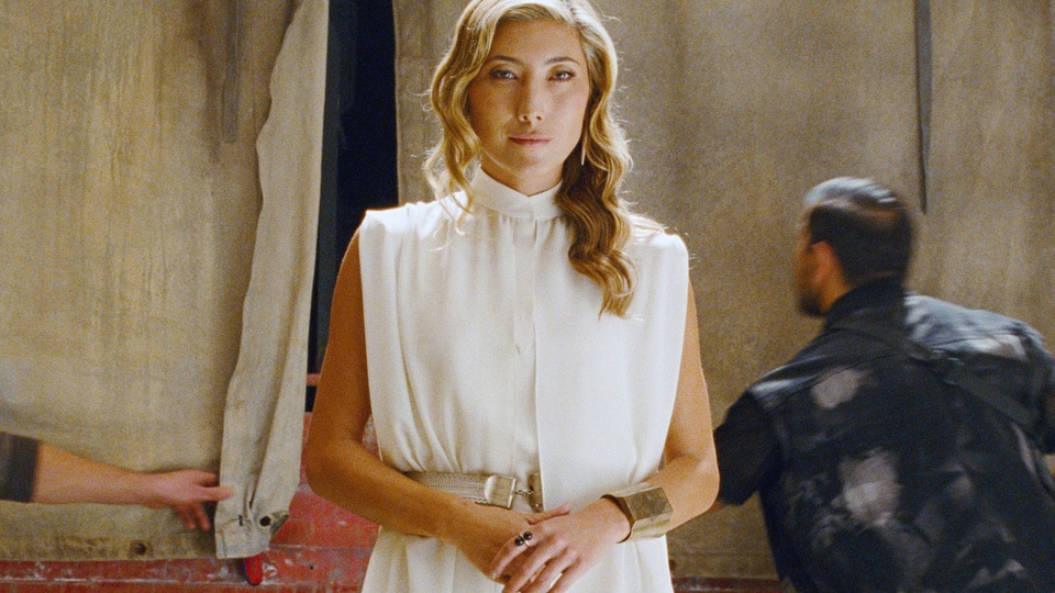 Soyona Santos (Dichen Lachman) wears a white gown in Jurassic World Dominion (2022).