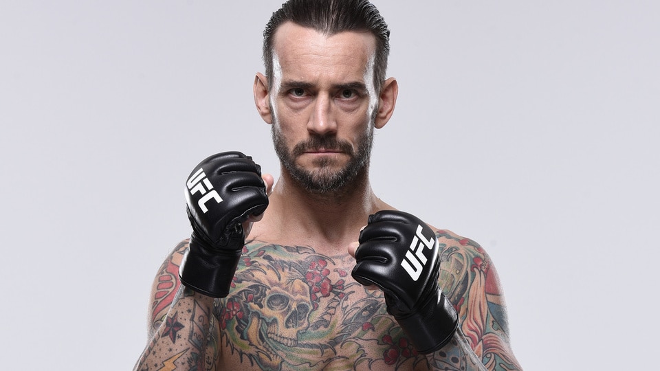 CM Punk poses shirtless with gloves.