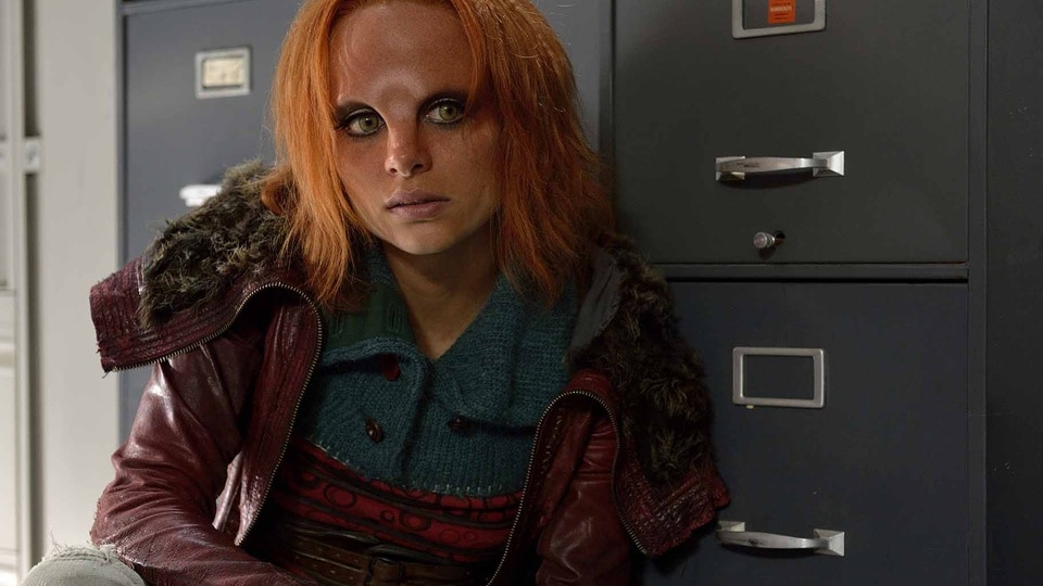 Irisa (Stephanie Leonidas) crouches near cabinets in Defiance Episode 111.