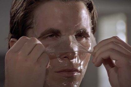 Christian Bale peels off a face mask in American Psycho (2000)