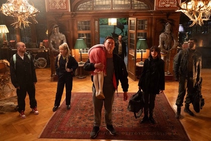 Peter (Kevin Durand) carries Abigail (Alisha Weir) while the cast stands next to him in Abigail (2024).