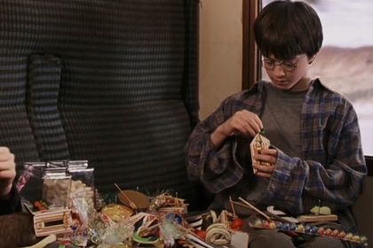 Harry Potter eats candy from a spread in Harry Potter and the Philosophers Stone (2001).
