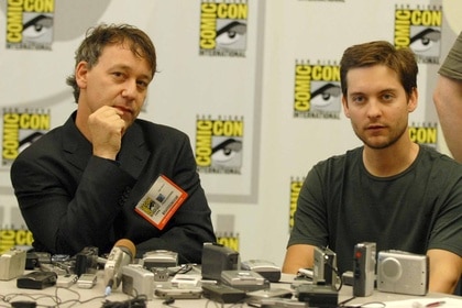 Sam Raimi and Tobey Maguire sit at a Comic-Con table.