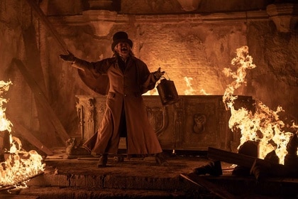 Professor Albin Eberhart von Franz (Willem Dafoe) cackles next to a fiery crypt.