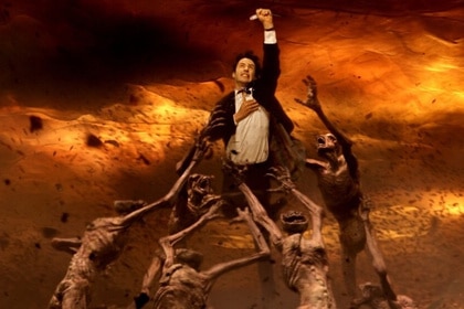 John Constantine (Keanu Reeves) is pulled by ghouls in a fiery hellscape in Constantine (2005).