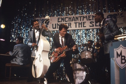 Michael J. Fox rocks out on a guitar with a band in Back To The Future (1985).