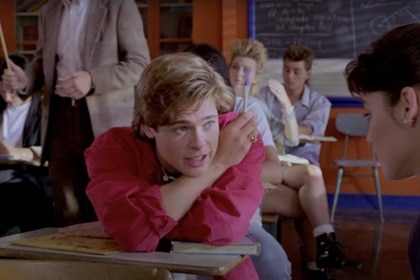 Dwight Ingalls (Brad Pitt) talks to a girl during class on Cutting Class (1989).