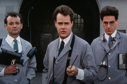 Peter Venkman (Bill Murray), Ray Stantz (Dan Aykroyd), and Egon Spengler (Harold Ramis) wear matching grey coats in Ghostbusters (1984).