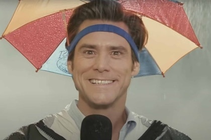 Bruce (Jim Carrey) smiles strangely in an umbrella hat in Bruce Almighty (2003).
