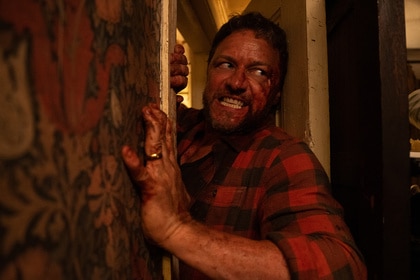 A bloody, angry Paddy (James McAvoy) squeezes through a door in Speak No Evil (2024).