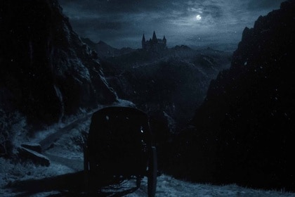 A carriage approaches Orlok’s castle in the dark in Nosferatu (2024).