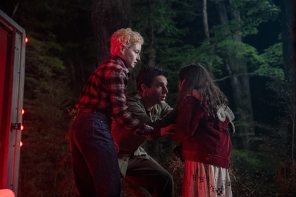 Charlotte (Julia Garner) and Blake (Christopher Abbott) worriedly tend to Ginger (Matilda Firth) in Wolf Man (2025).