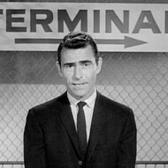 Rod Serling wears a suit and stands in front of sign that says "Terminal" on The Twilight Zone.