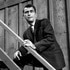 Rod Serling leans on a staircase railing on The Loner.