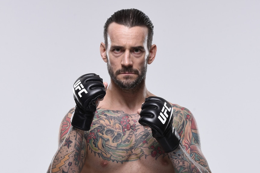 CM Punk poses shirtless with gloves.