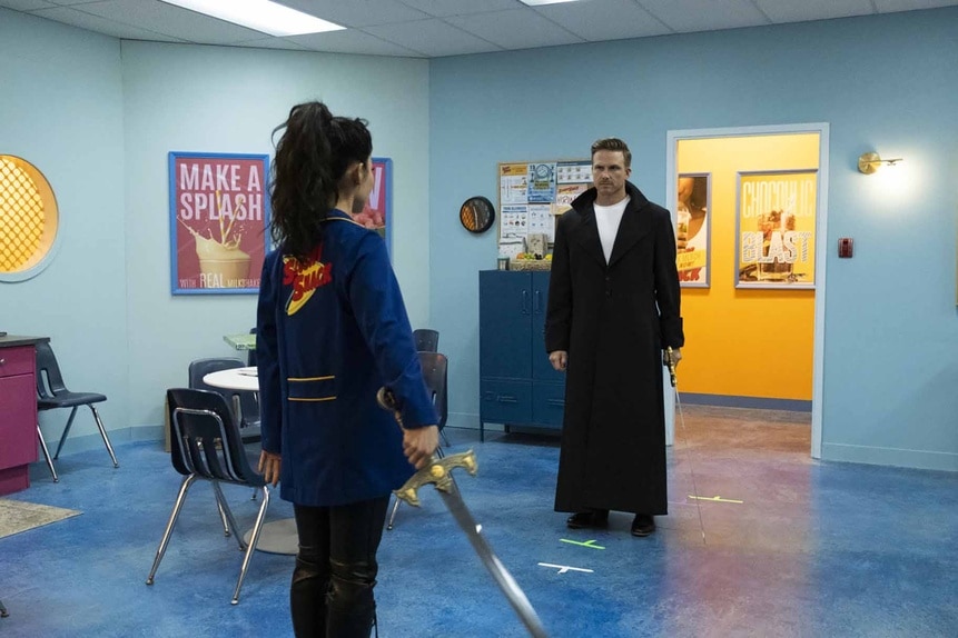 Nikki and Raphael face off in a break room with swords in Reginald The Vampire Episode 201.