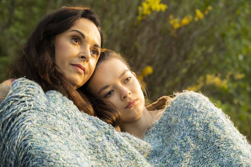 Ann (Françoise Robertson) and Claire (Thailey Roberge) cuddle under a blanket outside on Reginald the Vampire Episode 204.