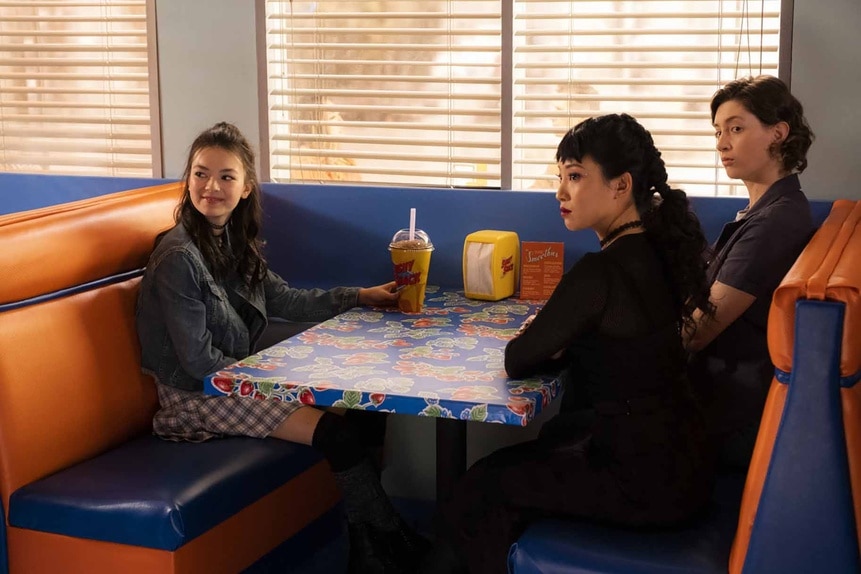 Claire (Thailey Roberge), Nikki (Christin Park), and Ashley Weeks (Marguerite Hanna) sit in a booth in Reginald the Vampire Episode 209.