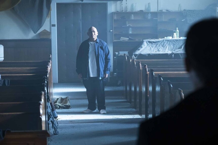 Reginald Andres (Jacob Batalon) stands in a church aisle on Reginald the Vampire Episode 210.