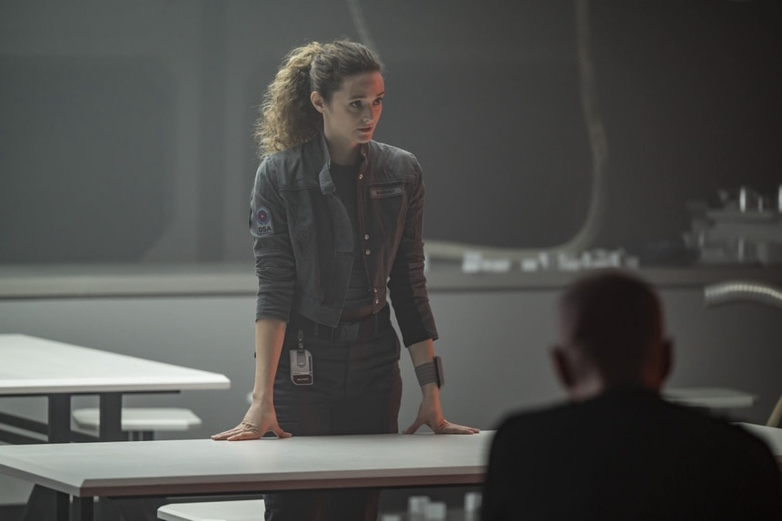 Lt. Sharon Garnet (Christie Burke) stands in front of a table in The Ark Episode 202.