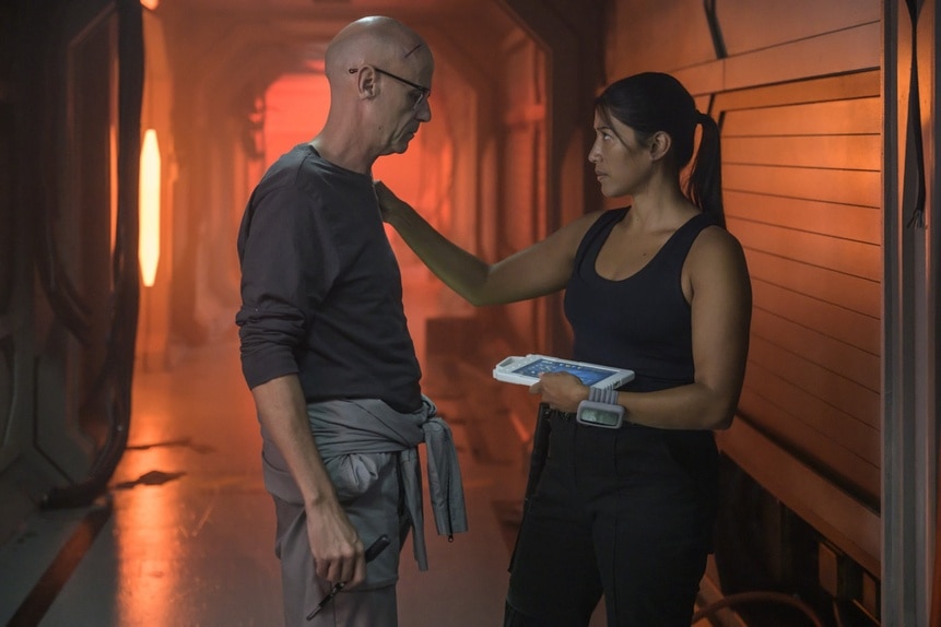 Kimi (Diana Bermudez) rests a hand on William Trust (Paul Leonard Murray) on The Ark Episode 203.