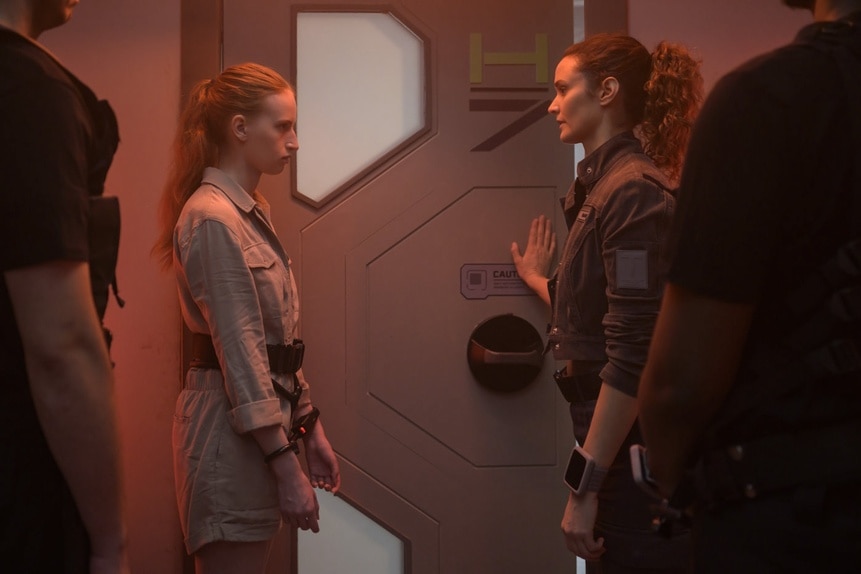 Kelly Fowler (Samantha Glassner) and Lt. Sharon Garnet (Christie Burke) speak near a door on The Ark Episode 203.