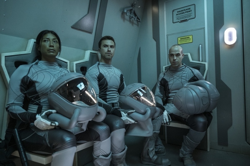 Kimi (Diana Bermudez), Lt. James Brice (Richard Fleeshman), and Felix Strickland (Pavle Jerinic) sit with large helmets in The Ark Episode 205.