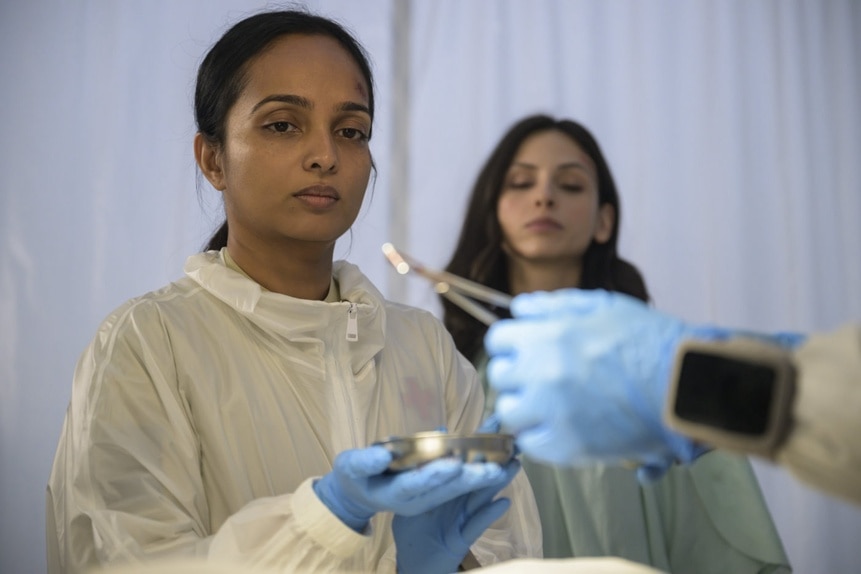 Dr. Sanjivni Kabir (Shalini Peiris) and Jelena Griff (Tamara Radovanovic) watches a small metal object be placed on a dish on The Ark Episode 206.