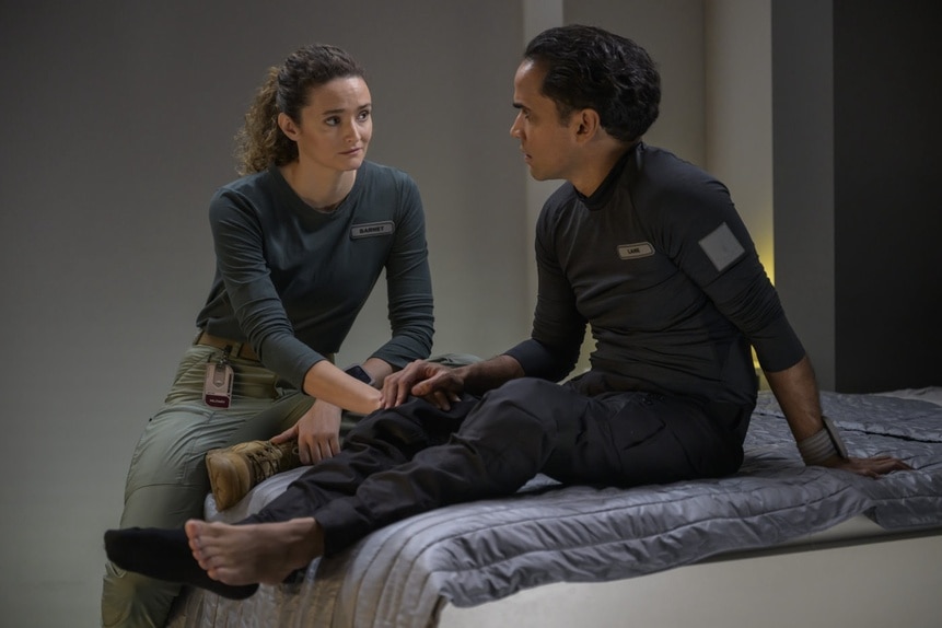 Lt. Sharon Garnet (Christie Burke) and Lt. Spencer Lane (Reece Ritchie) talk on a bed on The Ark Episode 206.