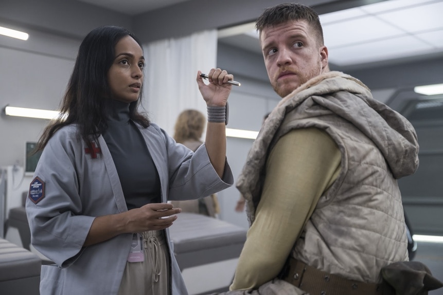 Dr. Sanjivni Kabir (Shalini Peiris) examines Milos Warren (Kieran Mortell) on The Ark Season Episode 207.