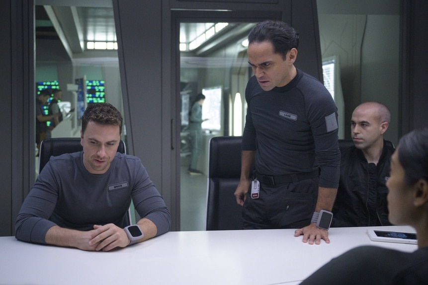 Lt. James Brice (Richard Fleeshman), Lt. Spencer Lane (Reece Ritchie), and Felix Strickland (Pavle Jerinic) discuss at a table on The Ark Episode 208.