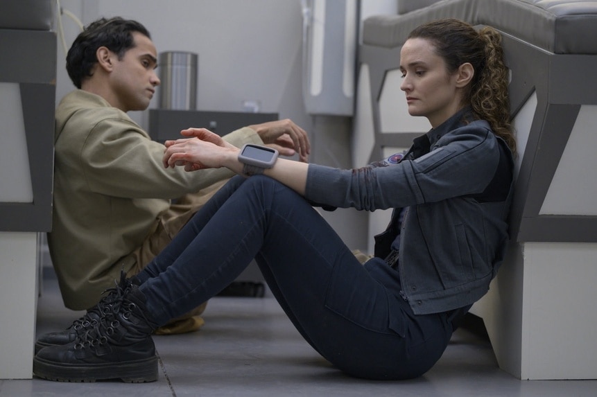 Ian (Reece Ritchie) and Lt. Sharon Garnet (Christie Burke) sit next to each other on the floor on The Ark Episode 209.